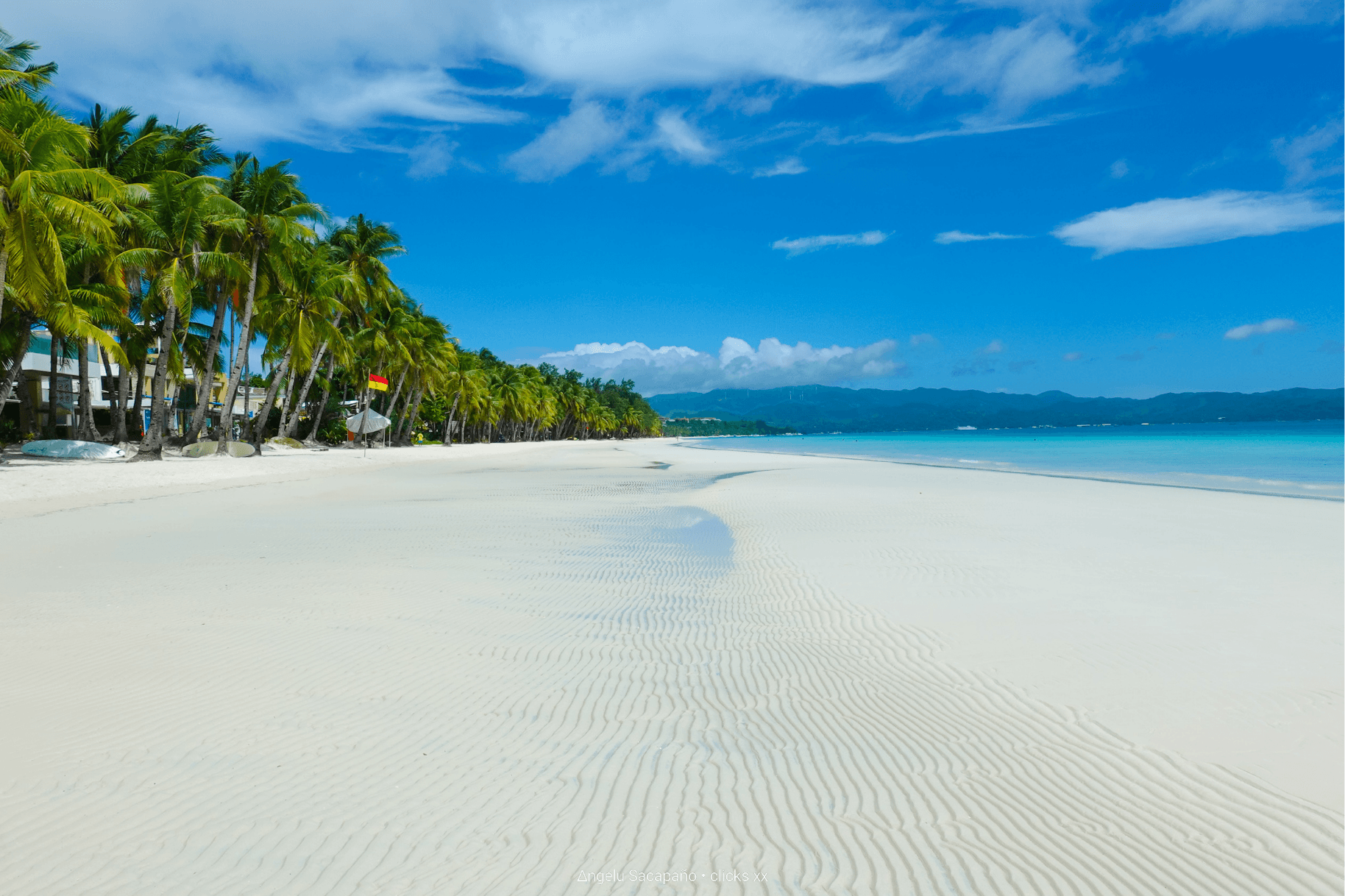 White Beach, Boracay at sunset with palm trees and calm water